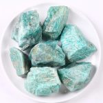 Natürliche türkisfarbene Mineraliensteine, ideal für Dekoration und wissenschaftliche Sammlungen, präsentiert auf weißem Teller.