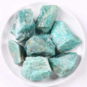 Natürliche türkisfarbene Mineraliensteine, ideal für Dekoration und wissenschaftliche Sammlungen, präsentiert auf weißem Teller.