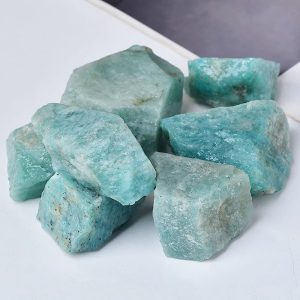 Rohaquamarin-Steine in verschiedenen Größen, natürliche Mineralien für Dekoration und Heilung, auf weißem Hintergrund.