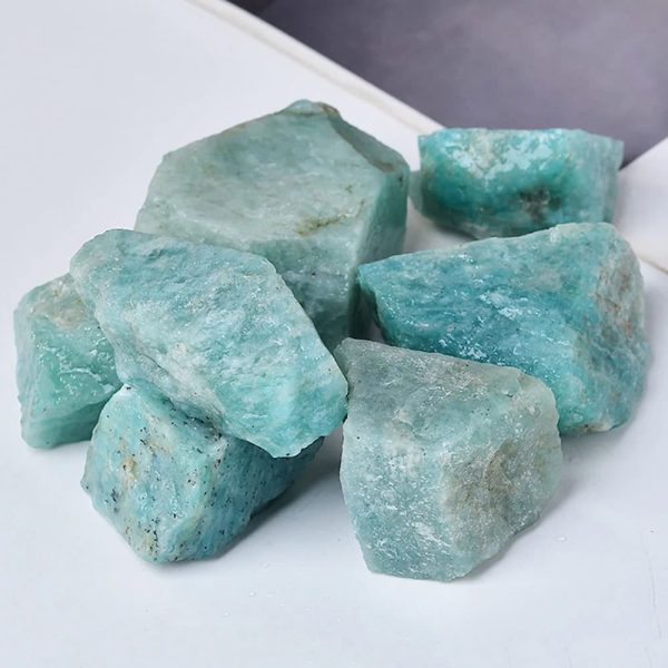 Rohaquamarin-Steine in verschiedenen Größen, natürliche Mineralien für Dekoration und Heilung, auf weißem Hintergrund.