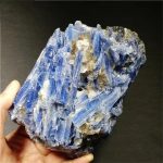 Nahaufnahme eines großen blauen Mineralien-Kristalls, der auf dunklem Hintergrund liegt, zeigt die komplexe Struktur und die leuchtende Farbe des Minerals.