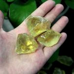 Natürliche gelbe Kristallsteine in einer Hand, ideal für wissenschaftliche Dekorationen und Sammlerstücke.