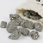 Natürliche Metallnuggets aus Silber oder Platin, die aus einem Stoffbeutel fallen, auf weißem Hintergrund. Perfekt für wissenschaftliche Dekorationen oder Sammlerstücke.