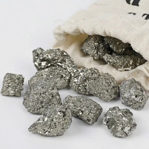 Natürliche Metallnuggets aus Silber oder Platin, die aus einem Stoffbeutel fallen, auf weißem Hintergrund. Perfekt für wissenschaftliche Dekorationen oder Sammlerstücke.