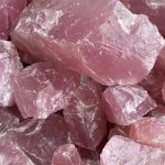 Nahaufnahme von rosa Rosenquarz-Kristallen mit glatter Oberfläche und natürlichen Strukturen.