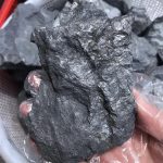 Nahaufnahme eines schwarzen Mineralsteins, der in der Wissenschaft und Dekoration verwendet wird, mit einer rauen, unregelmäßigen Oberfläche.