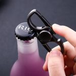 Hand hält einen Rauchverschluss für Flaschen, der mit einem Karabiner befestigt ist, auf einem dunklen Hintergrund.