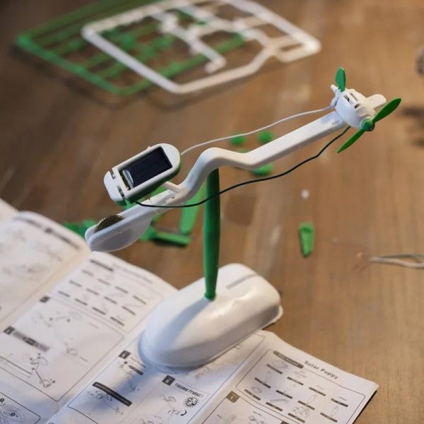 Wissenschaftliches Spielzeugmodell eines kleinen Flugzeugs mit Solarzelle, grünen Propellern und beweglichen Teilen, ideal für Bildung und Dekoration.