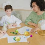 Kinder lernen Astronomie mit einem Modell des Sonnensystems, das bunte Planeten und Himmelskörper zeigt, während sie im Klassenzimmer oder zu Hause spielen und entdecken.