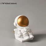 Niedliche Astronautenfigur aus Keramik mit goldfarbenem Helm, ideal als wissenschaftliche Dekoration oder Geschenk für Weltraumfans.