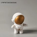 Niedliche Astronautenfigur als Dekorationsobjekt, ideal für Science-Fiction- und Weltraumthemen, mit einem goldfarbenen Helm und weißen Raumanzug, perfekt für Sammler und Dekorationszwecke.