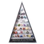 Sammlung verschiedener Edelsteine in einer Pyramide, inklusive Aquamarin, Rubin, Saphir, Amethyst und mehr, präsentiert in einer transparenten Pyramidenschale.
