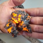 Meteoriten mit leuchtender, glühender Oberfläche, die beim Halten in der Hand sichtbar ist, zeigt die faszinierende Natur eines extraterrestrischen Gesteins.
