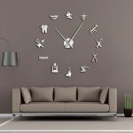 Moderne Wanduhr mit wissenschaftlichen Symbolen, die auf einer grauen Wand über einem stilvollen Sofa angebracht ist. Perfekt für Wissenschafts- und Technikliebhaber.