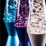 Drei Lava-Lampen mit leuchtenden, glitzernden Flüssigkeiten in Blau, Lila und Transparent, ideal für Dekoration und wissenschaftliche Experimente.
