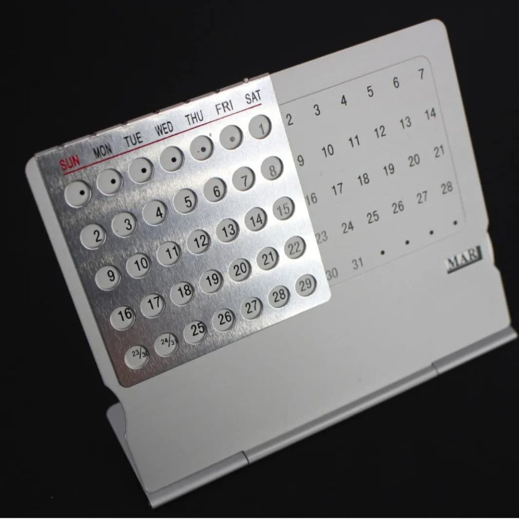 Kalender mit magnetischen Markierungen für Termine und Planung, auf einem weißen Ständer, ideal für Büro oder Zuhause.
