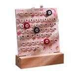 Dekorativer Kalender mit niedlichen Hasenmotiven, Monats- und Tagesanzeigen, ideal für Kinderzimmer oder als Geschenk, aus Holz und Kunststoff gefertigt.