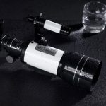 Hochauflösendes Teleskop mit Wassertröpfchen auf der Oberfläche, ideal für wissenschaftliche und dekorative Zwecke, auf schwarzem Hintergrund.