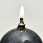 Nahaufnahme eines Feuerzeugs mit brennender Flamme, ideal als wissenschaftliches Dekorationsstück oder für kreative Raumgestaltung.