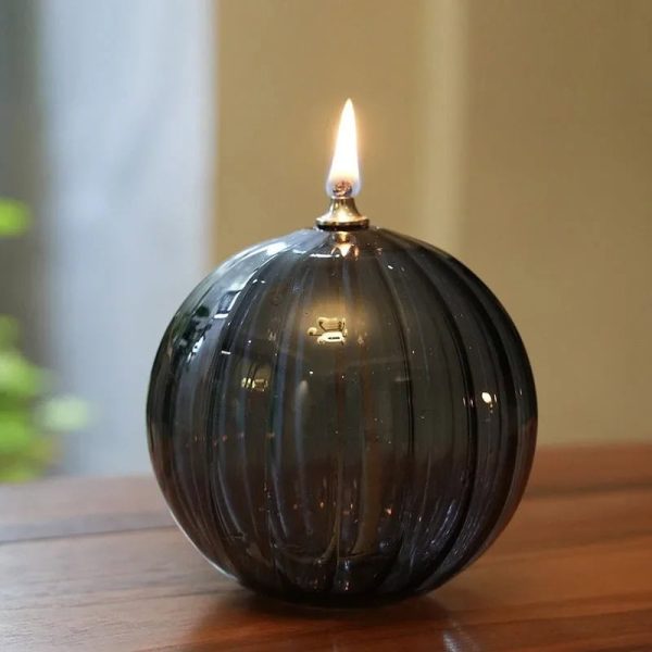 Elegante schwarze Glasvase mit brennender Kerze, ideal für Dekoration und stimmungsvolle Beleuchtung.