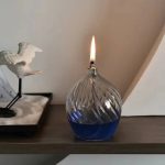 Dekoratives Glas-Feuerlampe mit blauer Flüssigkeit und Flamme, ideal für wissenschaftliche Dekorationen und moderne Inneneinrichtung.
