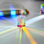 Kristall mit Lichtreflexionen, der auf einer weißen Oberfläche steht, erzeugt bunte Lichtstreifen.