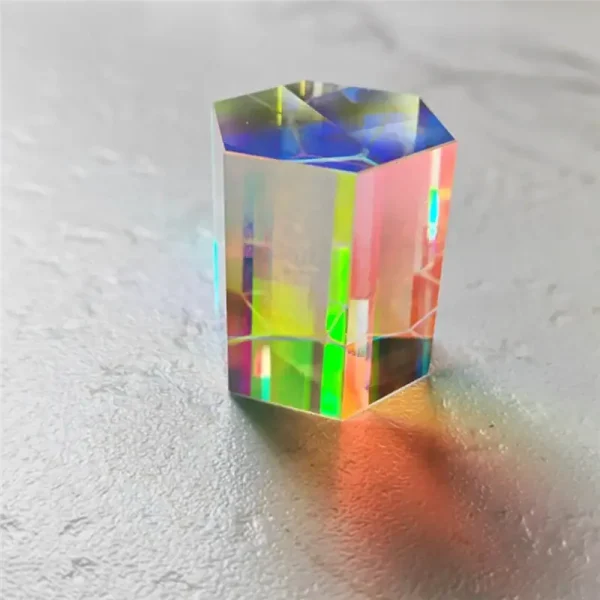 Holografischer Kristall aus Glas mit Regenbogenreflexionen, auf hellem Hintergrund.