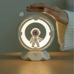Moderne Raumfahrt-Dekoration mit einem kleinen Astronautenmodell, das in einem futuristischen, leuchtenden Kreis schwebt, ideal für Science-Fiction- und Weltraumfans.