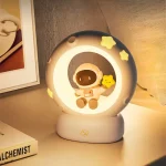 Nachtlicht mit Astronautenmotiv, das einen kleinen Astronauten in einem Kreis mit Sternen zeigt, ideal für Kinderzimmer und als dekoratives Beleuchtungsstück.