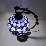 Elegante Tiffany-Glaslampe mit buntem, geometrischem Muster, ideal als Dekoration und Lichtquelle in Wohnräumen.