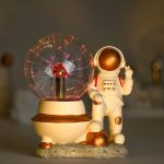 Miniatur-Astronaut neben einem Glas mit elektrischem Feuerball, der Blitze erzeugt, ideal für wissenschaftliche Dekorationen und Gadgets.