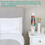 Bunter Luftdiffusor auf Nachttisch neben Bett, Rainbow-Lampe reflektiert farbige Lichter im Raum, schafft eine entspannte Atmosphäre.