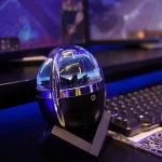 Moderner Kristallball mit LED-Beleuchtung auf einem Schreibtisch, umgeben von Computer und Tastatur, ideal für wissenschaftliche Dekorationen und Gadgets.