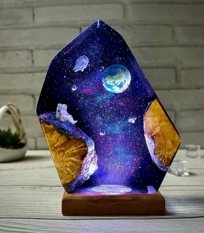 Dekorativer Glasblock mit Weltraummotiv, zeigt Erde, Mond und Astronaut im Universum, beleuchtet für eine faszinierende Raumdekoration.