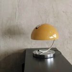 Elegante, vintage-inspirierte Schreibtischlampe mit gelbem Schirm und silbernem Arm, perfekt für moderne und klassische Arbeitsbereiche.