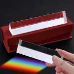 Dispersionsprisma, das Sonnenlicht in Regenbogenfarben bricht, auf schwarzem Hintergrund.