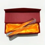 Elegantes Glasprisma in einer roten Geschenkbox mit goldener Innenseite, ideal für wissenschaftliche Dekorationen und Experimente.