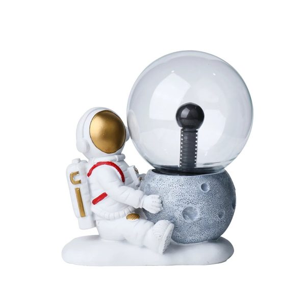 Niedliche Raumfahrer-Figur neben einer Mond- und Glaskugel-Dekoration, ideal für wissenschaftliche und dekorative Zwecke.