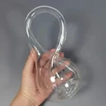 Transparentes Glasobjekt in Schleifenform, ideal für wissenschaftliche Dekorationen und Experimente.