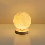 Kreative Mondphasen-Lampe, die den Mond in warmem Licht auf einem runden Sockel zeigt, ideal für Dekoration und wissenschaftliche Atmosphäre.
