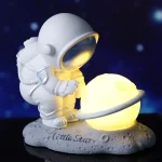 Niedliches Sternenkapitän-Design mit leuchtender Planetlampe auf einem Mond-Base, ideal für Science-Fan-Dekorationen und Kinderzimmer.