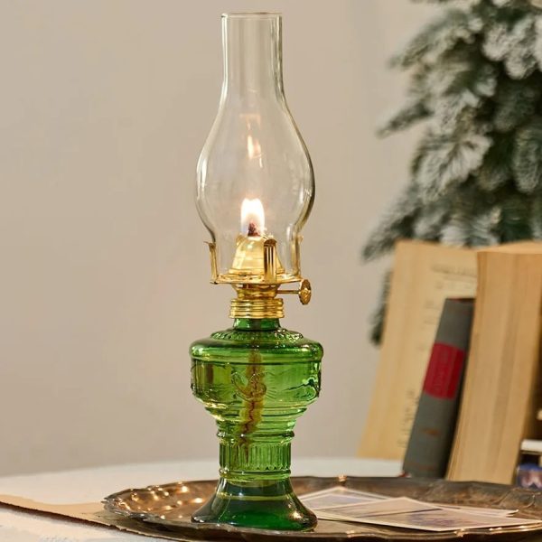 Alt-Öllampe aus grünem Glas mit offener Flamme, dekoratives antikes Design.