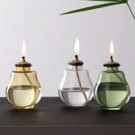 Drei stilvolle Kerzenlampen in transparenten Glasgefäßen mit brennenden Kerzen, ideal für wissenschaftliche Dekorationen und moderne Raumgestaltung.