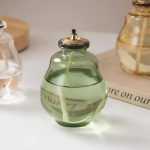 Dekorativer Zerstäuber in einer grünen Glasflasche mit Metallverschluss, ideal für wissenschaftliche Dekorationen oder als stilvolles Accessoire.
