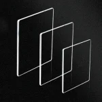 Drei transparente Glasplatten in unterschiedlichen Größen, schwebend in einer geometrischen Anordnung auf schwarzem Hintergrund.