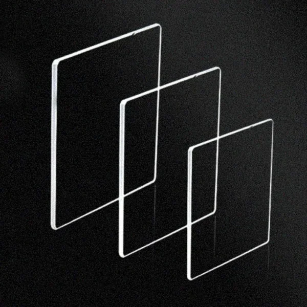 Drei transparente Glasplatten in unterschiedlichen Größen, schwebend in einer geometrischen Anordnung auf schwarzem Hintergrund.