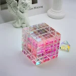 Bunter, reflektierender Kristallwürfel aus Glas mit Lichtspielen, auf weißem Hintergrund, dekoratives wissenschaftliches Objekt.