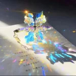 Glitzernder Schmetterling Anhänger aus Kristall mit schillerndem Lichtreflex, ideal für Schmuck und Dekoration, reflektiert bunte Lichter auf Papier.