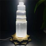 Leuchtende Salzlampe in Form einer mehrstufigen Säule, die warmes Licht ausstrahlt und eine entspannte Atmosphäre schafft.