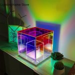 Bunte Neon-Lichtbox auf einem Tisch, die verschiedene Farben und geometrische Formen projiziert, ideal für moderne Raumdekoration und kreative Beleuchtung.